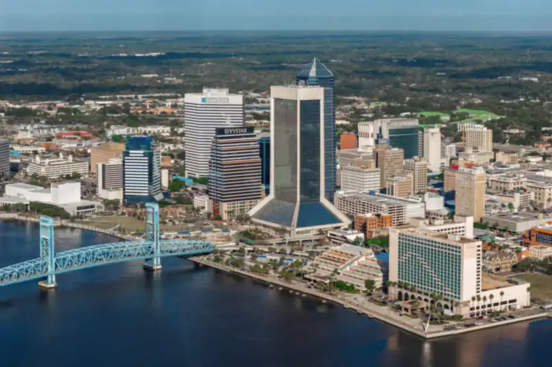 Aerial view of downtown Jacksonville towers and a blue bridge over the St. Johns River