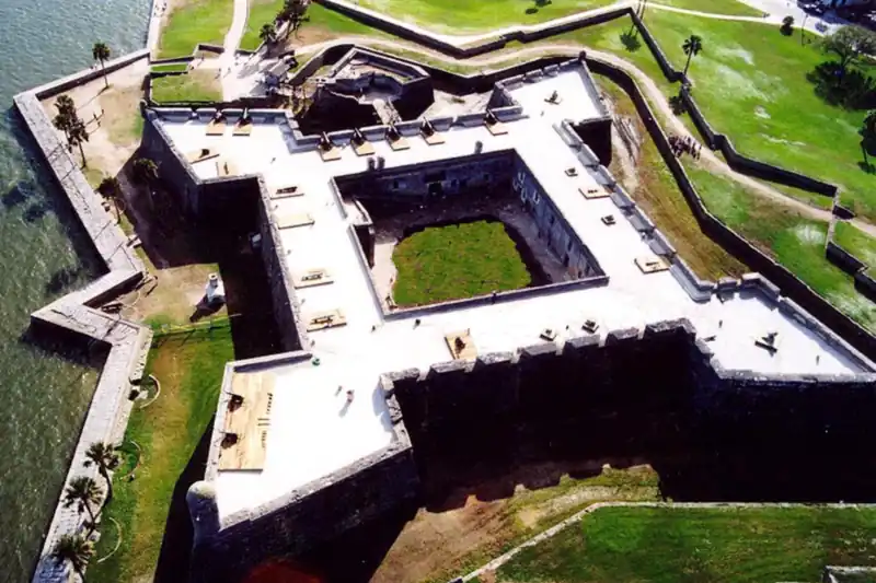 Aerial view of a star-shaped stone fort beside the water