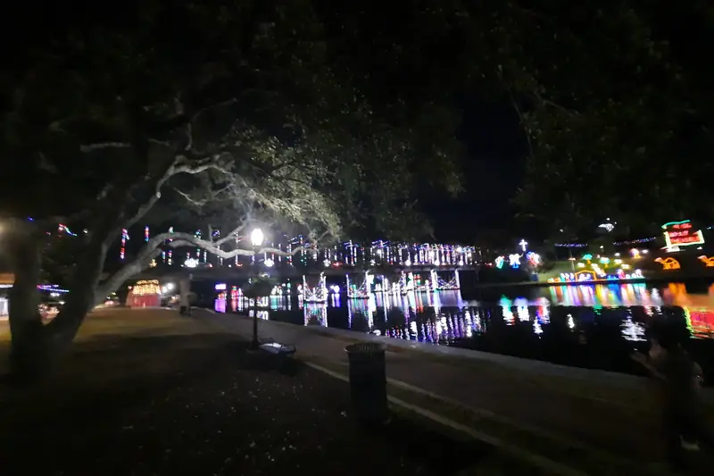 Strings of colored Christmas lights reflected in the Cane River at night in Natchitoches