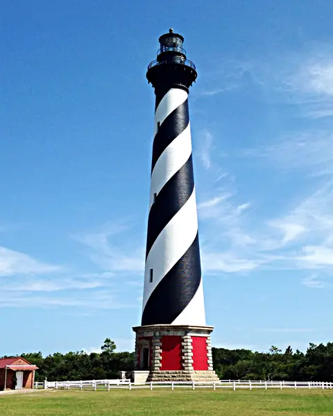 Black-and-white spiral-striped Cape Hatteras Lighthouse under a blue sky