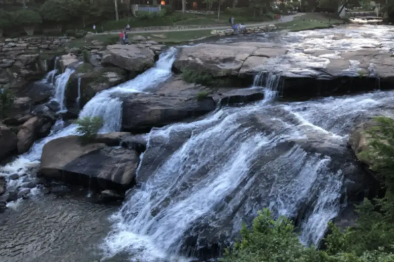 Water spilling over wide rock ledges at Falls Park in Greenville